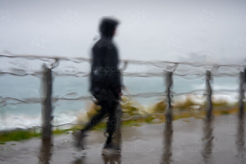 Walking in the rain, shot through a wet car window - Australian Stock Image