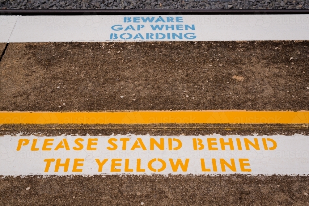 Warning sign to "Beware gap" and 'Stand behind the yellow line' at Harden railway station - Australian Stock Image