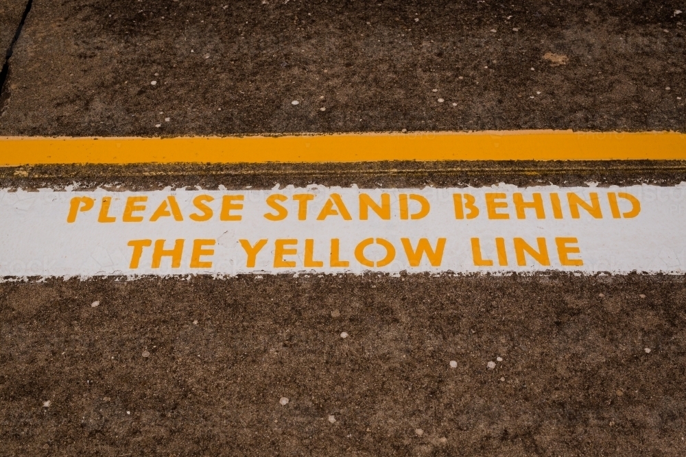 warning sign to 'Please stand behind the yellow line' at harden railway station - Australian Stock Image