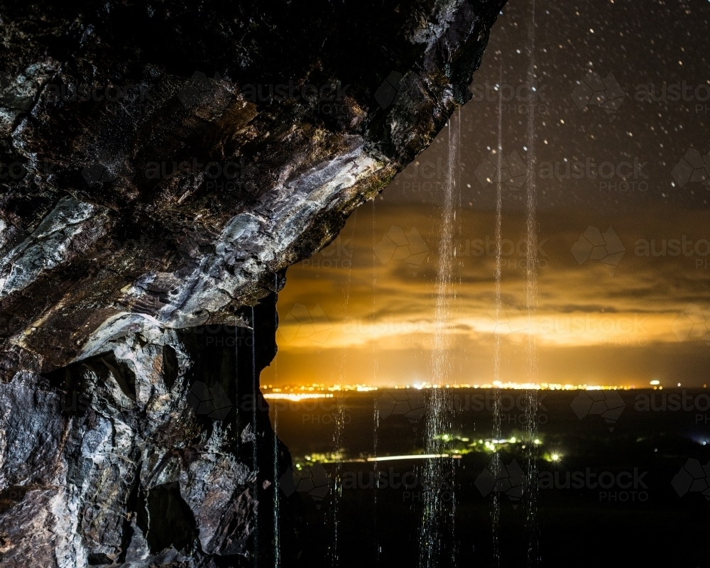 Waterfall against the nighttime lights of the Sunshine Coast - Australian Stock Image