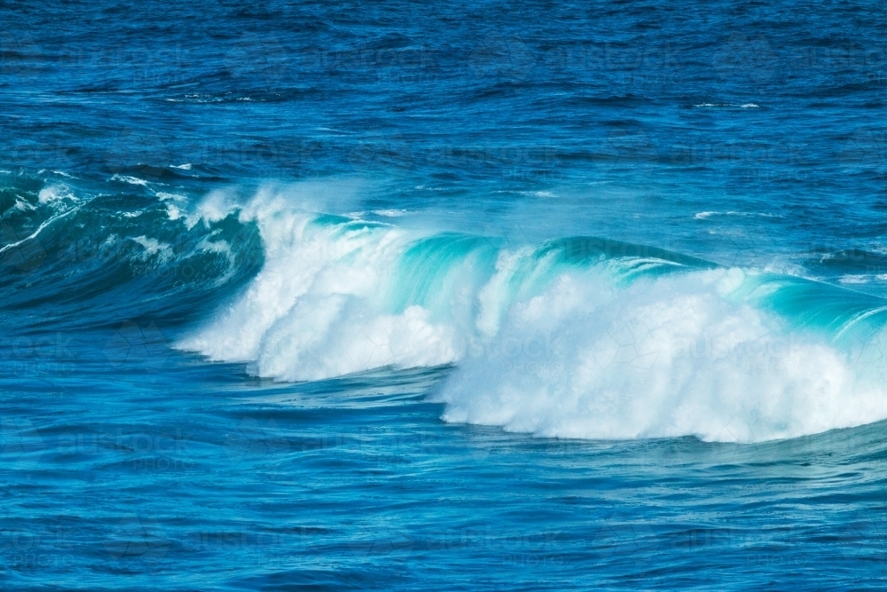 wave tumbling on blue water - Australian Stock Image