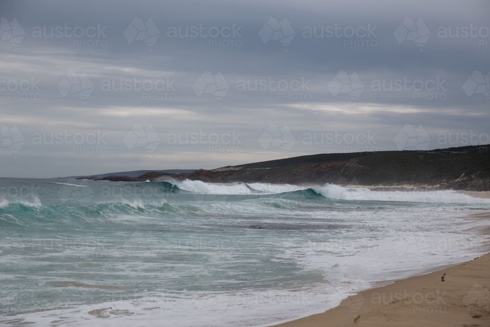 Waves breaking on an overcast day at the beach - Australian Stock Image