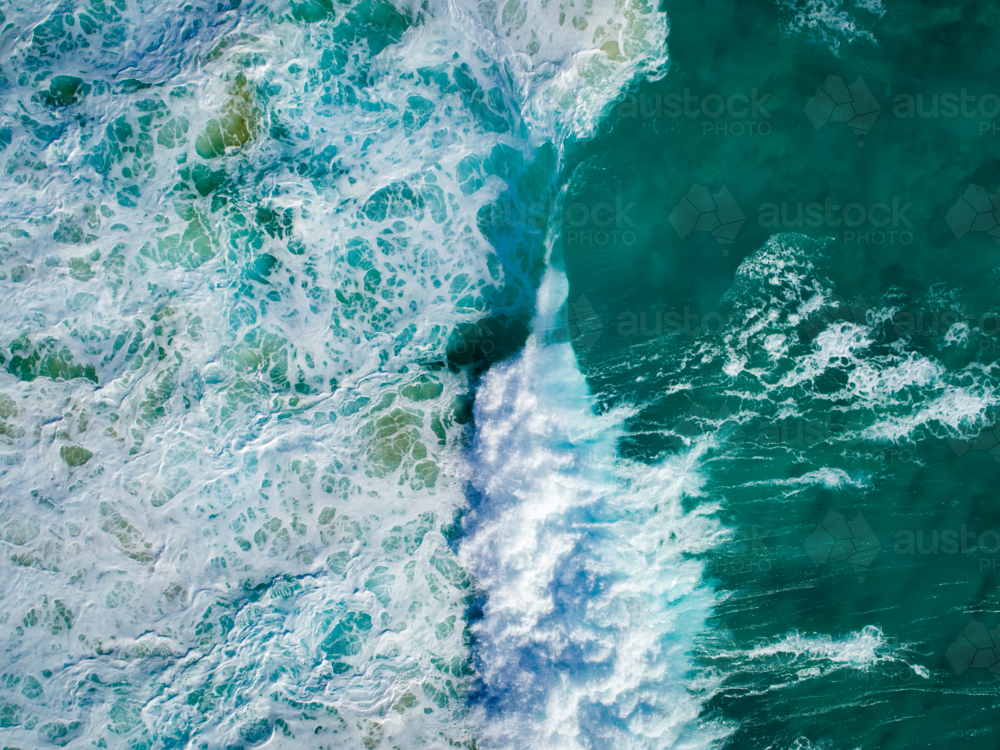 Waves crash in a concentrated pocket over a shallow reef - Australian Stock Image