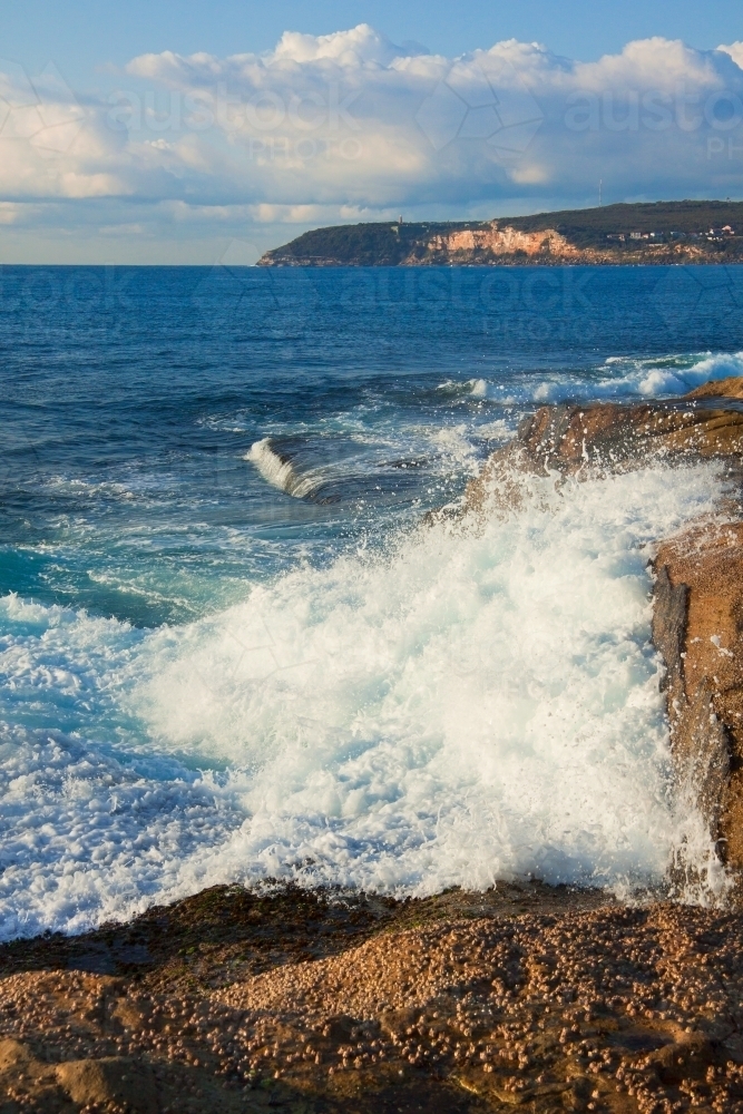 Waves crashing into rocky cliffs - Australian Stock Image