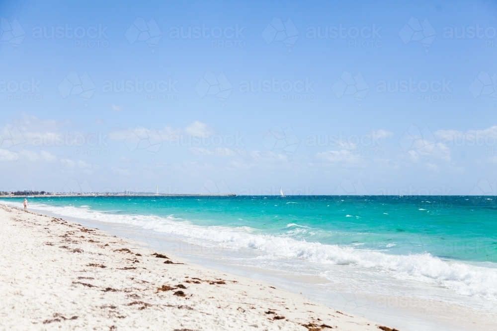 Waves wash up on white beach sand - Australian Stock Image