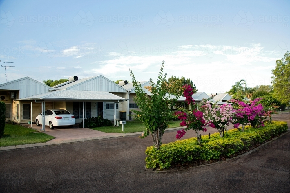 Weatherboard home in a picturesque street with hedge in the middle of the road. - Australian Stock Image