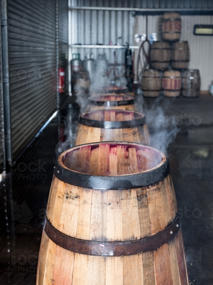 Whisky barrels lined up while being charred - Australian Stock Image