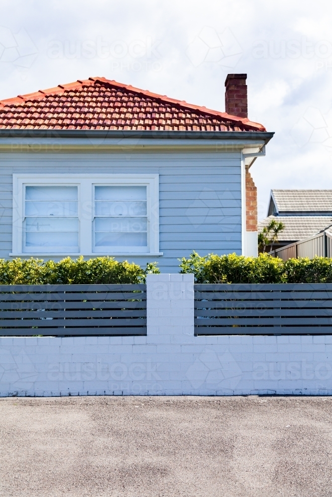 White house with red tiled roof on street - Australian Stock Image