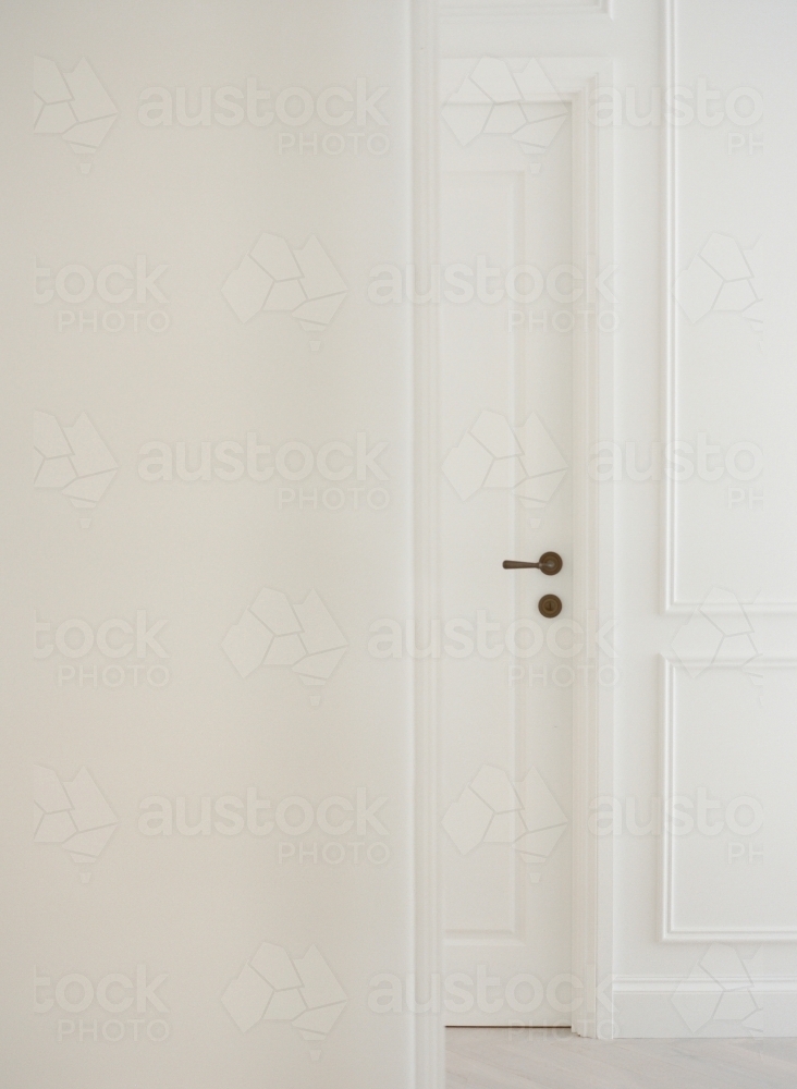 White on white interiors with antique brass door handle details - Australian Stock Image