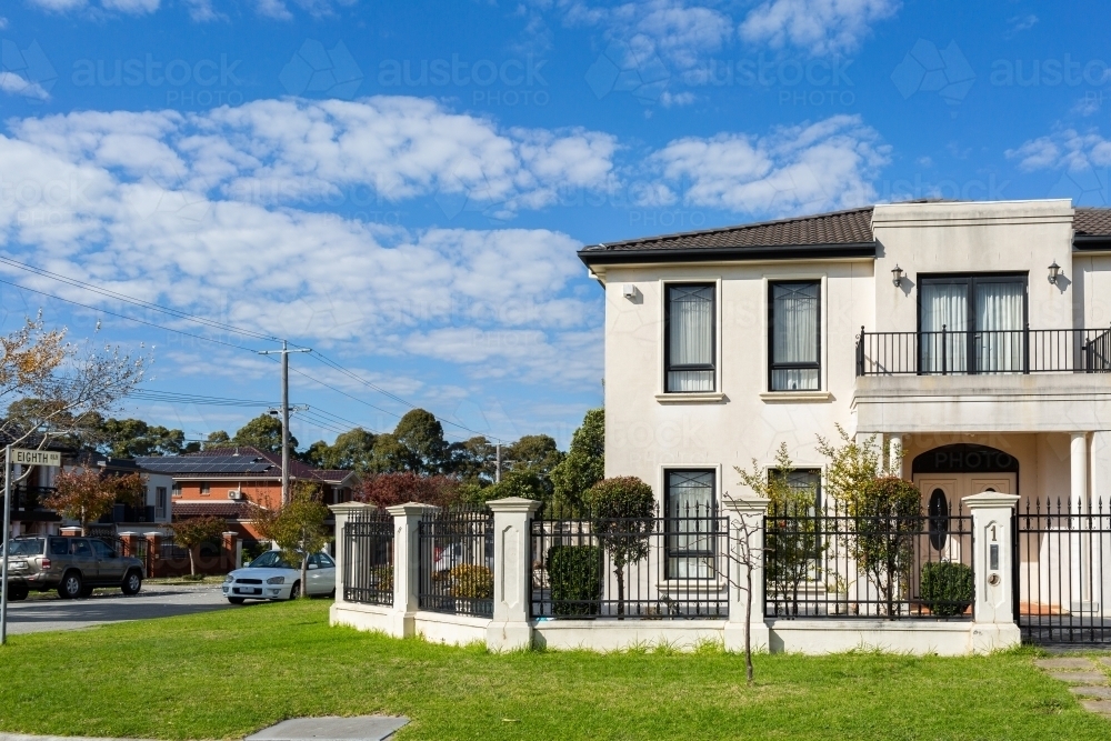 White two storey house on corner with balcony - Australian Stock Image