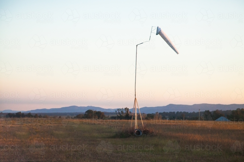 White wind sock blowing at dusk on Elderslie airstrip - Australian Stock Image