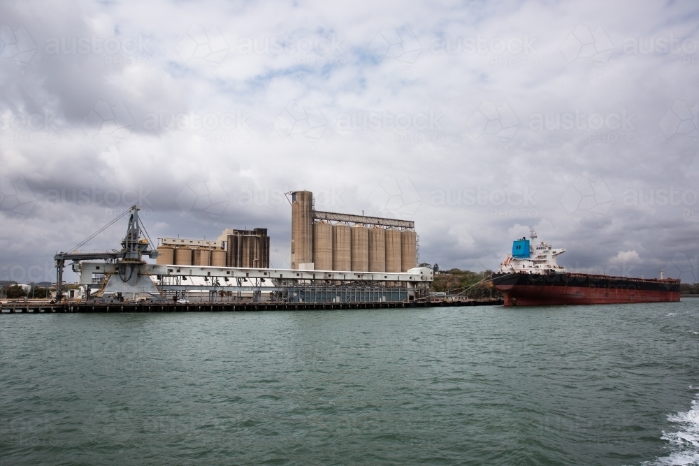 Image of wide shot of Gladstone Harbour with ships and silos - Austockphoto