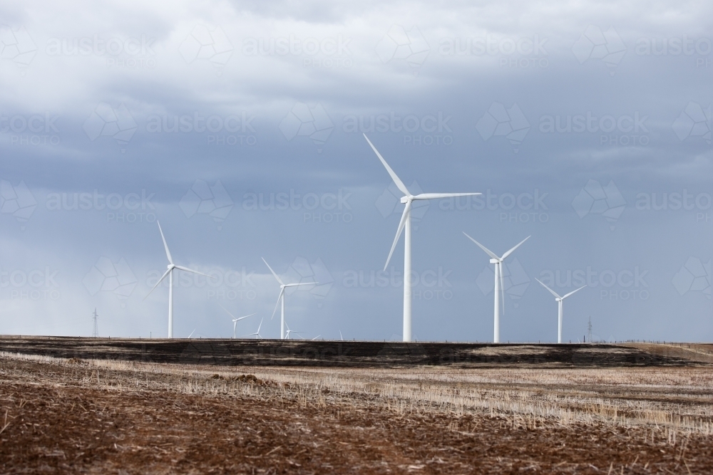 Wind farm in paddock with incoming storm - Australian Stock Image