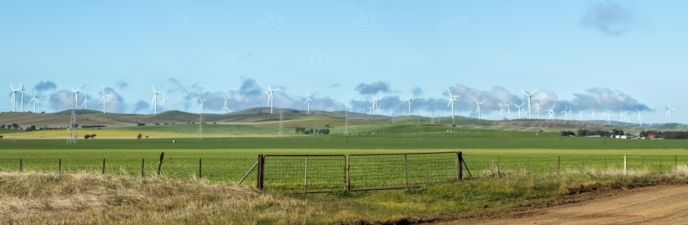 Wind farm on hills with green paddocks in front - Australian Stock Image