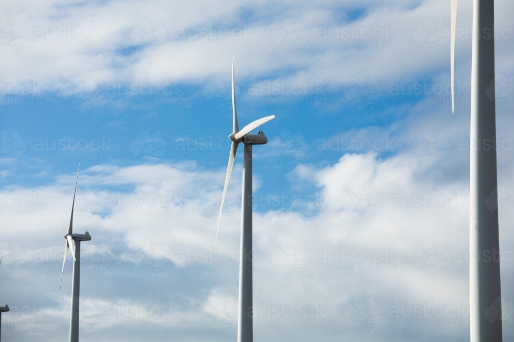 Wind turbines in a row against a cloudy sky - Australian Stock Image