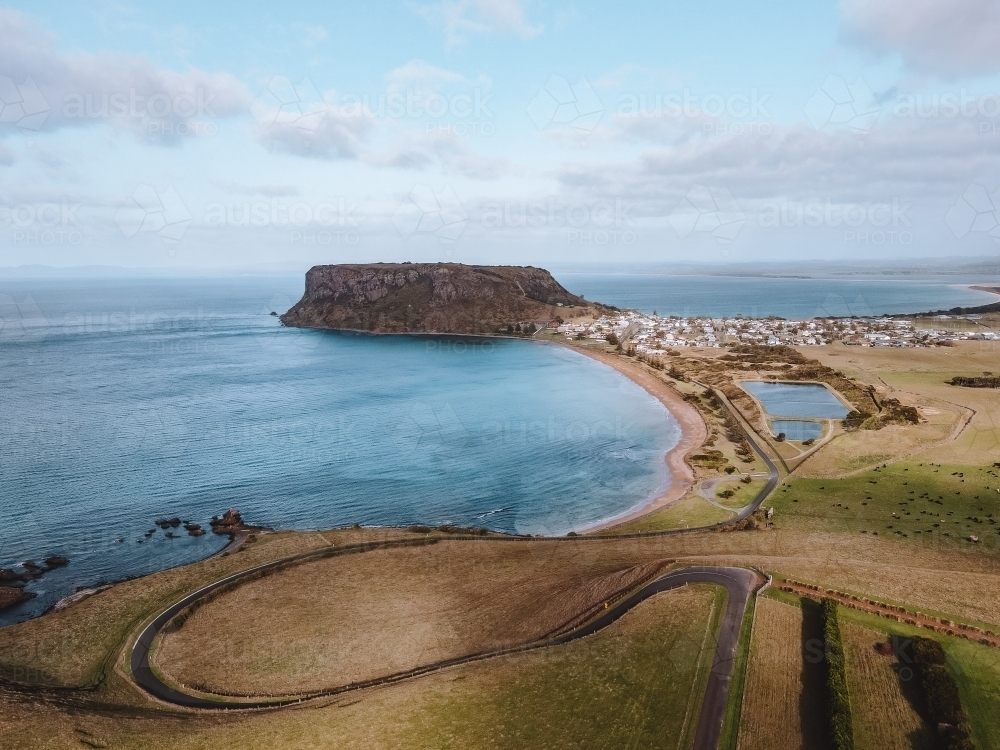 Winding coastal road towards a small village and The Nut at Stanley. - Australian Stock Image