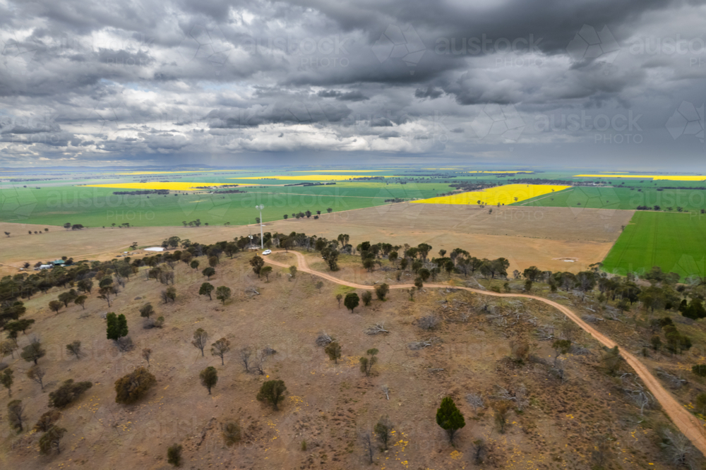 Winding dirt road in sparsely vegetated land - Australian Stock Image