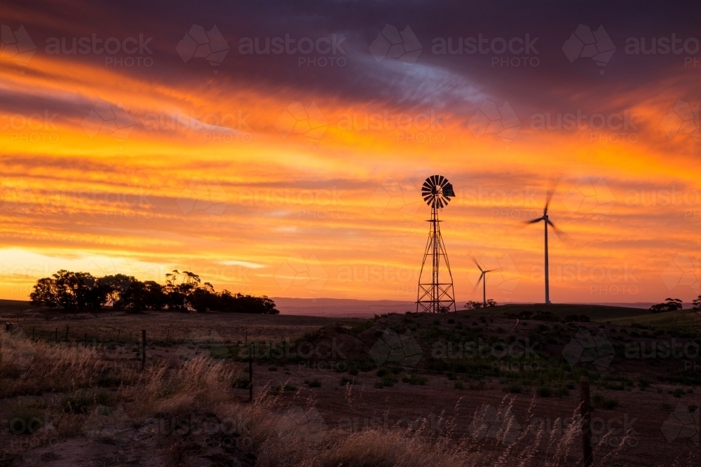 Windmill and wind turbines silhouetted against sunset - Australian Stock Image