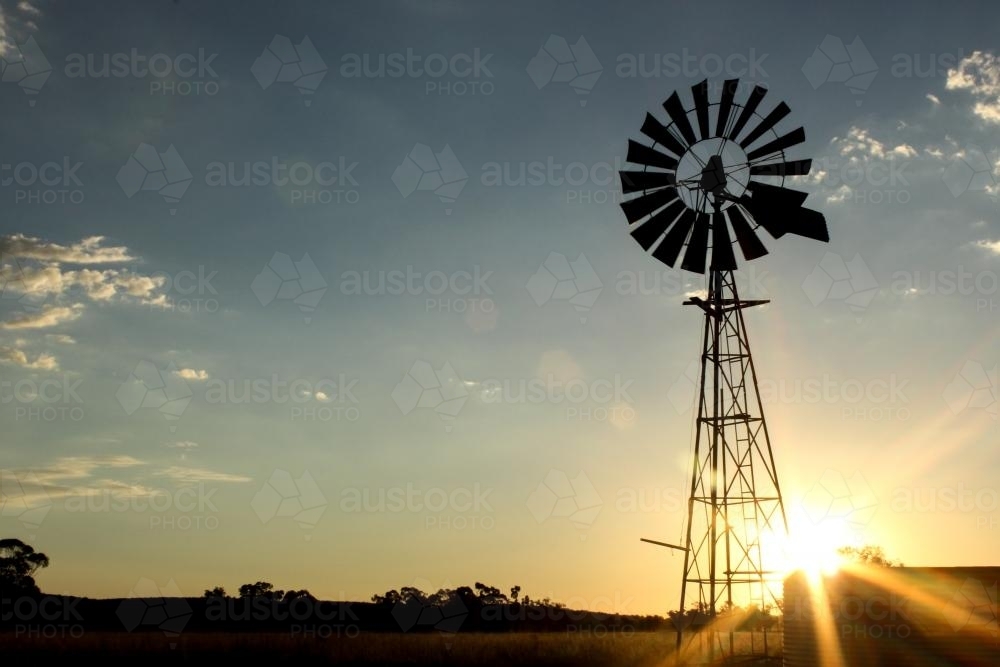 Windmill on a farm at sunset - Australian Stock Image