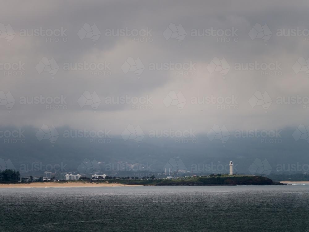 Wollongong lighthouse in a pool of light on an very overcast day - Australian Stock Image