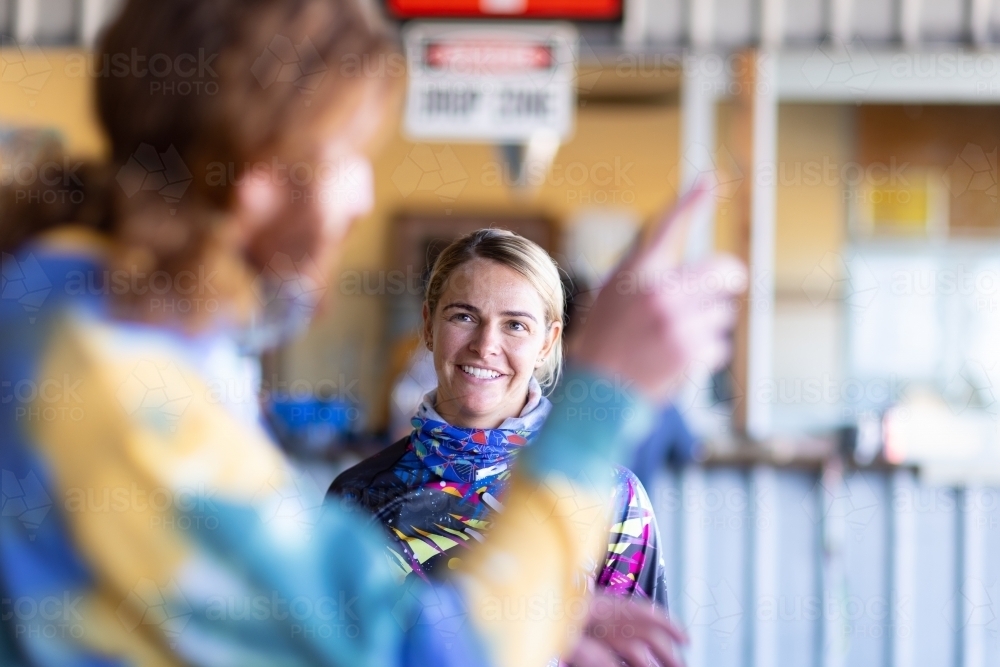 woman being given instructions by man blurred in foreground - Australian Stock Image