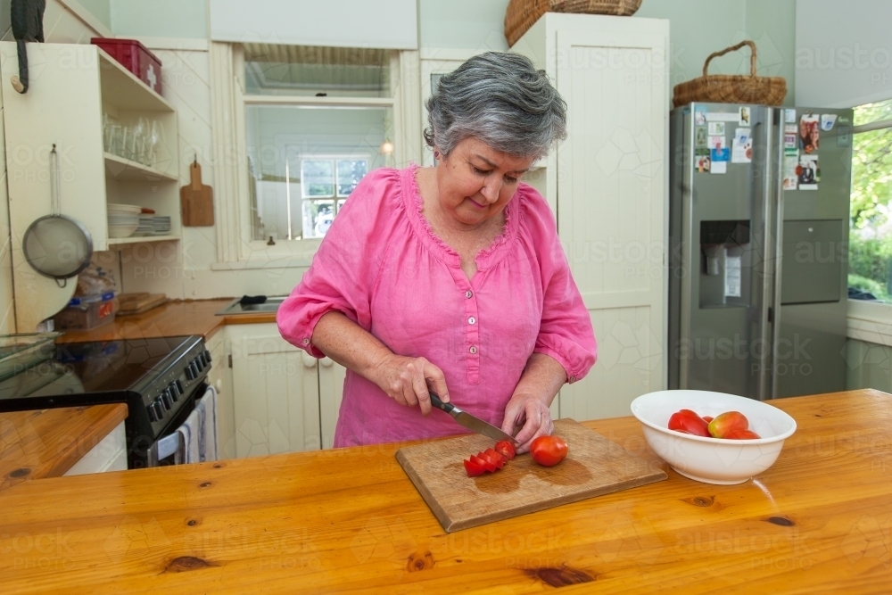 Woman cutting tomatoes - Australian Stock Image