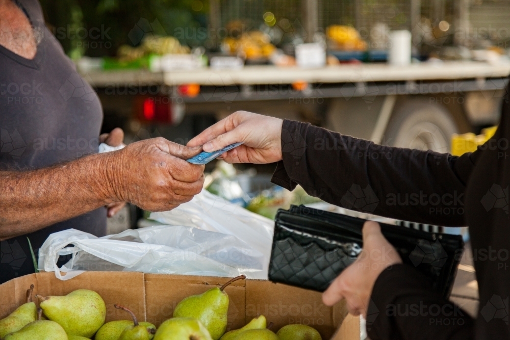 Woman handing cash over to Aussie farmer at produce stall - Australian Stock Image