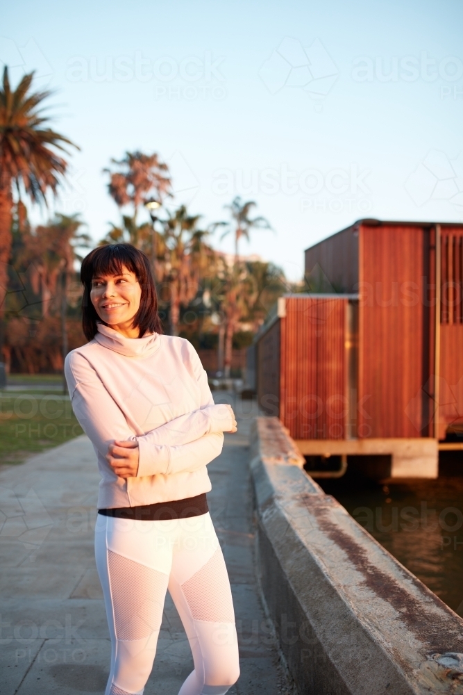 Woman harbourside in a happy mood at sunrise - Australian Stock Image