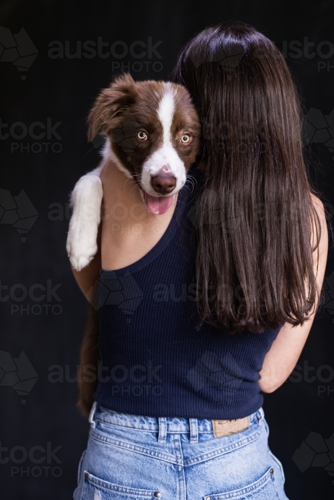 woman holding dog on her shoulder - Australian Stock Image