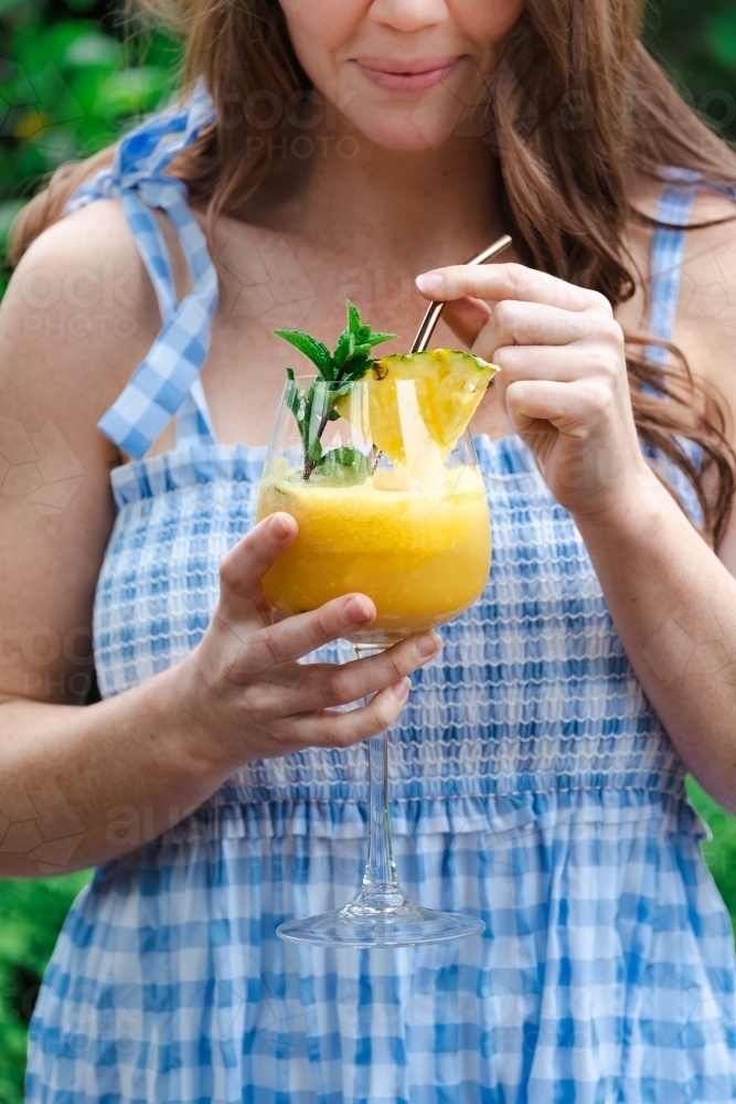 Woman holding fruit cocktail drink. - Australian Stock Image