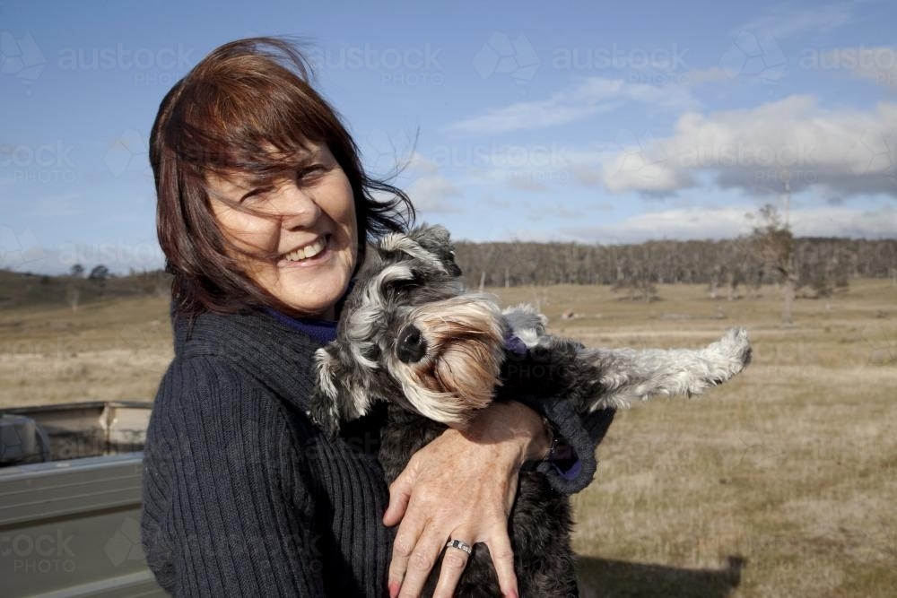 Woman holding her dog smiling and laughing - Australian Stock Image