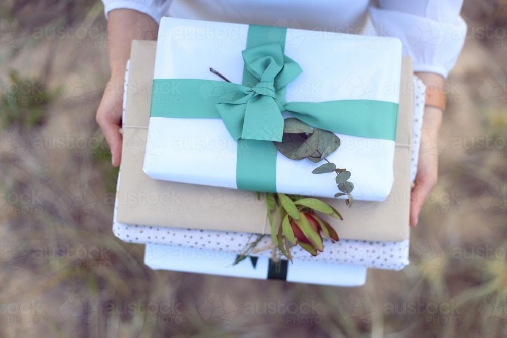 Woman holding presents at beach - Australian Stock Image