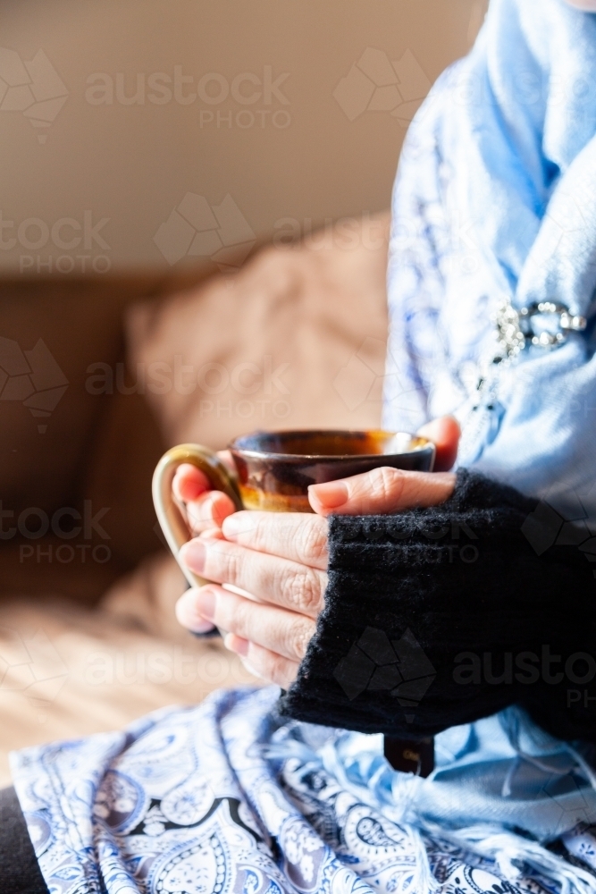 Woman holding warm mug of chai tea in winter - Australian Stock Image