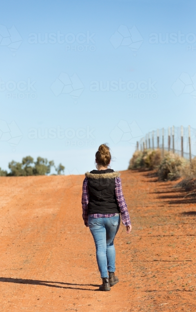 Woman in the outback walking away from camera - Australian Stock Image