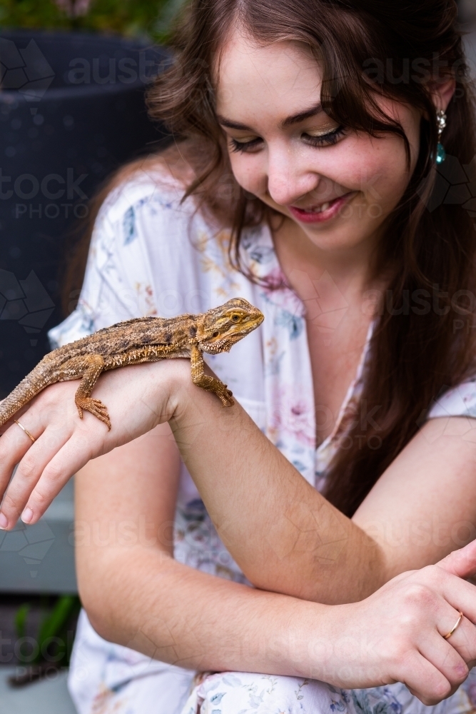 Woman interacting with pet bearded dragon lizard - Australian Stock Image