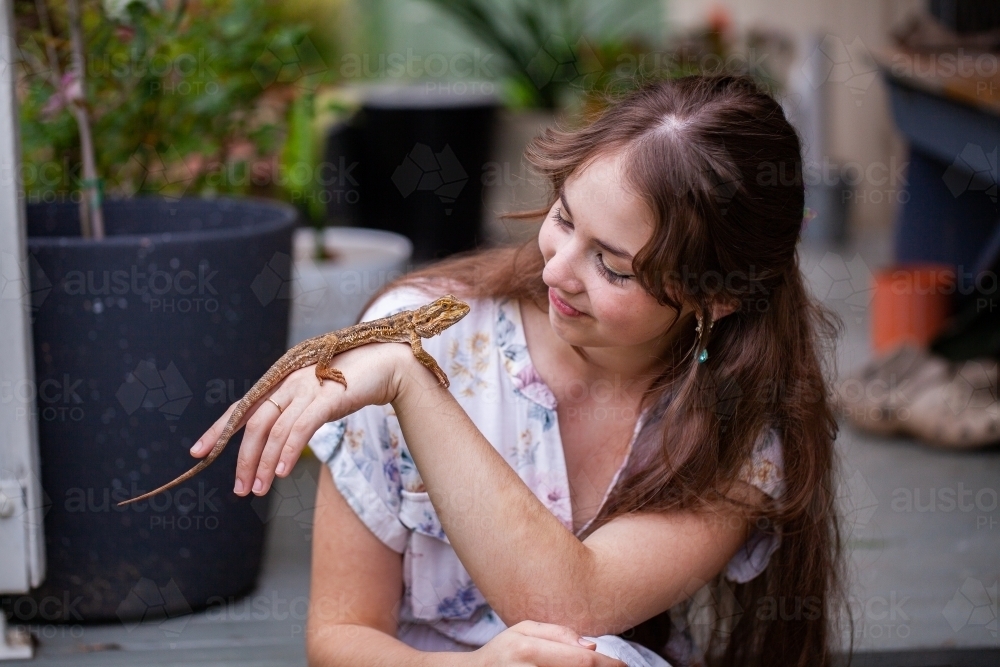 Woman interacting with pet bearded dragon lizard - Australian Stock Image