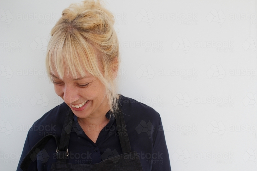 Woman looking down laughing - Australian Stock Image