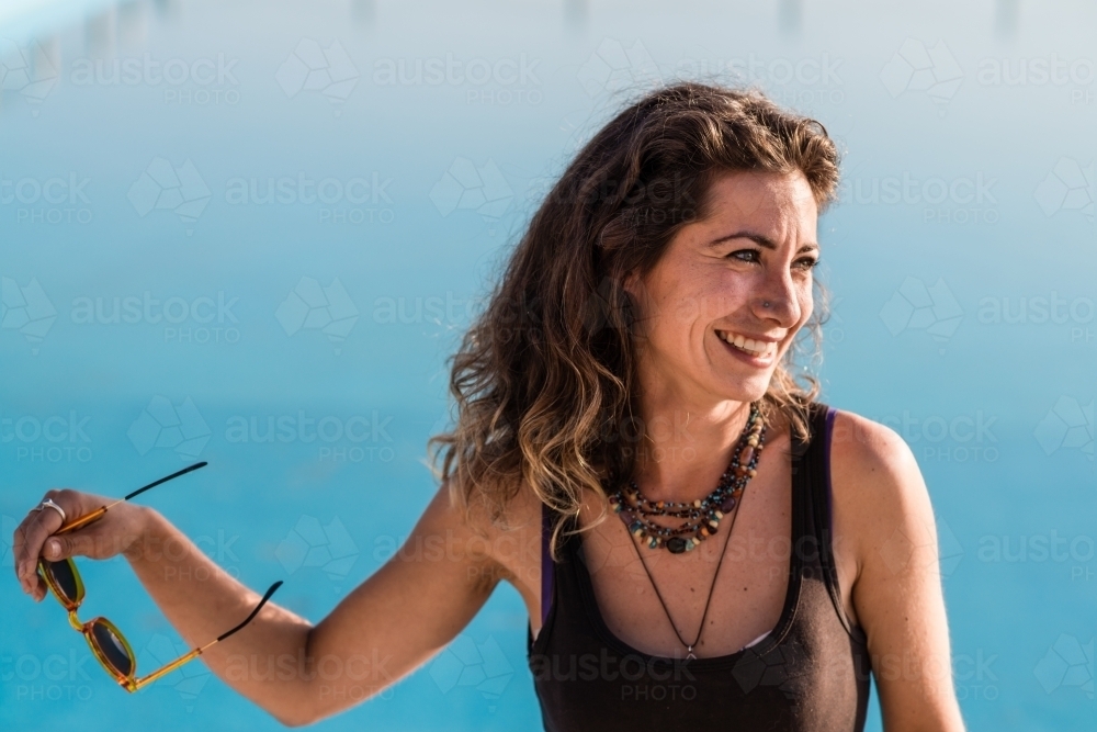 woman putting on sunglasses in the bright light - Australian Stock Image