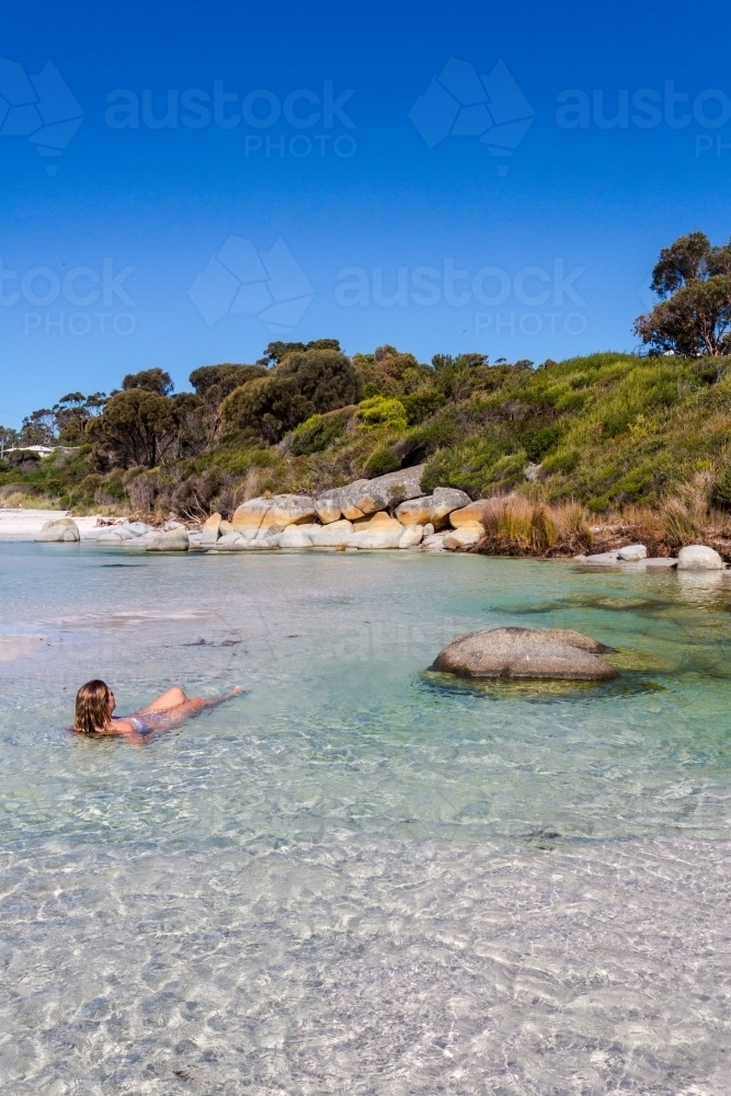 Woman sea bathing in crystal clear waters of Tasmania - Australian Stock Image