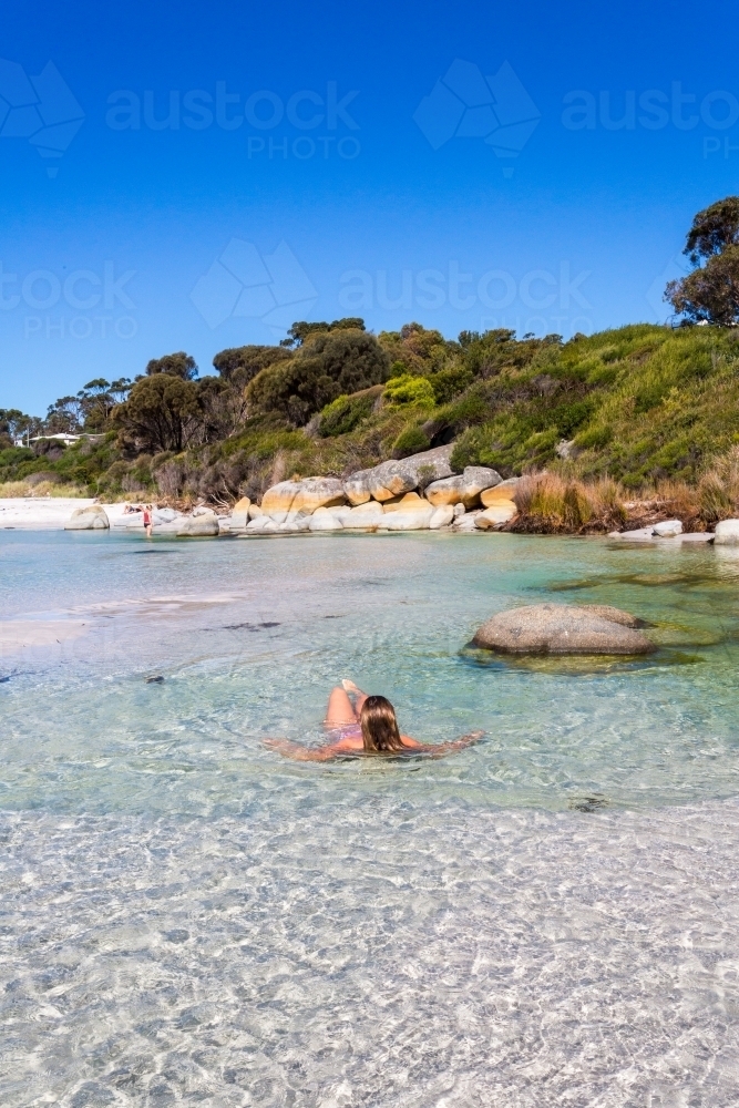 Woman sea bathing in crystal clear waters of Tasmania - Australian Stock Image