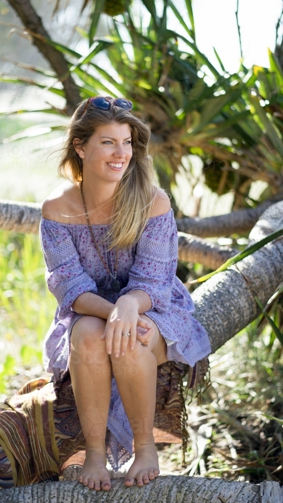 Woman sitting on beach looking away - Australian Stock Image