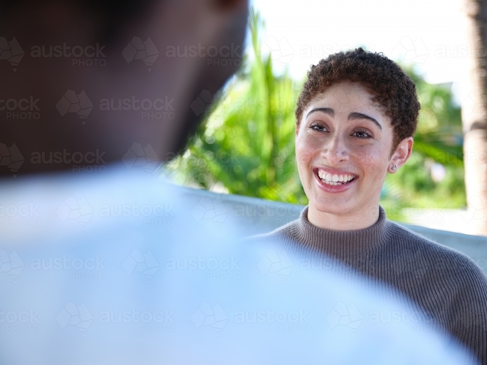 Woman smiling during a conversation outside - Australian Stock Image