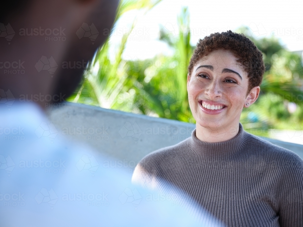 Woman smiling during a conversation outside - Australian Stock Image