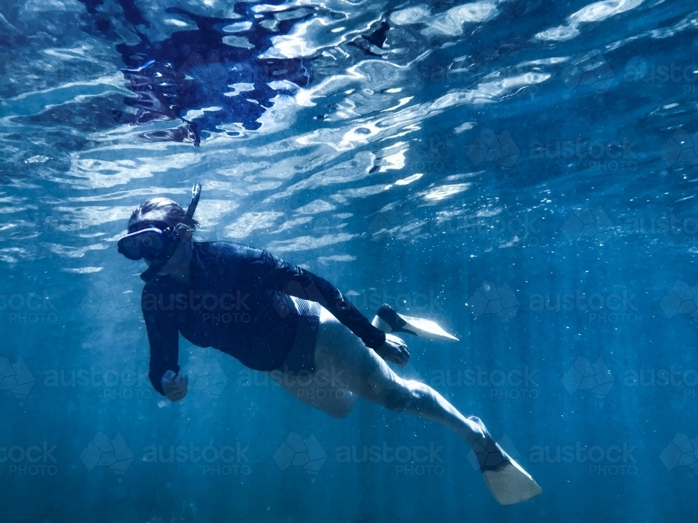 Woman snorkelling underwater in ocean - Australian Stock Image