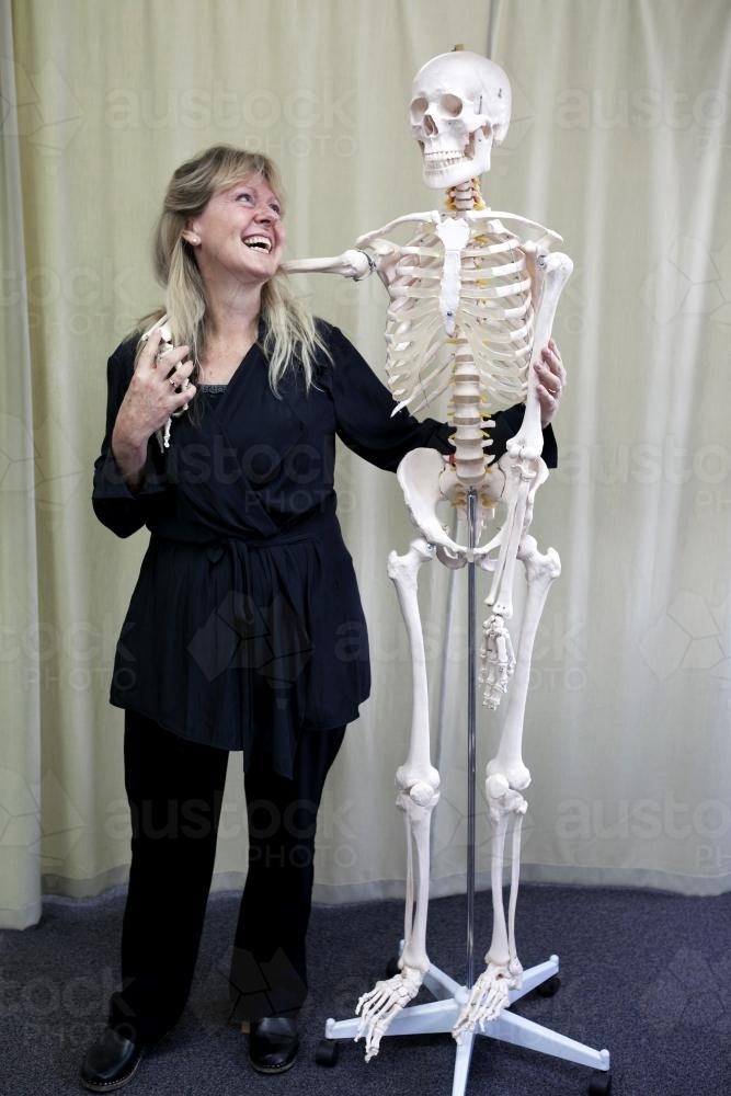 Woman standing and laughing with skeleton - Australian Stock Image