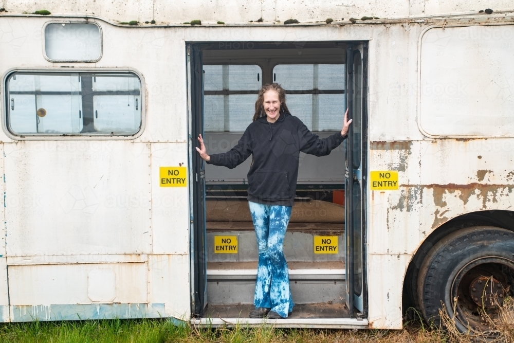 Woman standing at the exit of an old bus. - Australian Stock Image