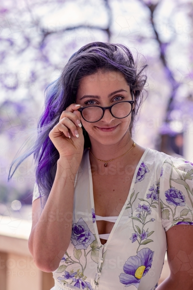 Woman standing in front of jacaranda tree - Australian Stock Image