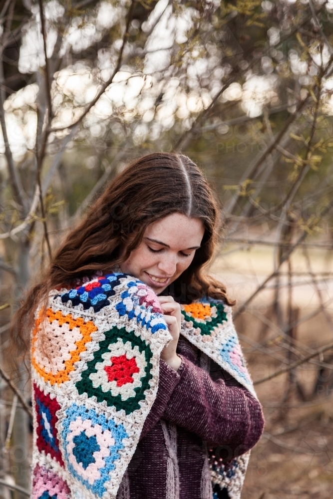 Woman standing outside with jumper and blanket in winter - Australian Stock Image