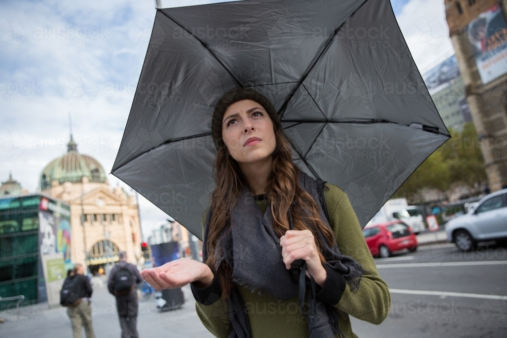 Woman standing with umbrella in classic Melbourne Weather - Australian Stock Image