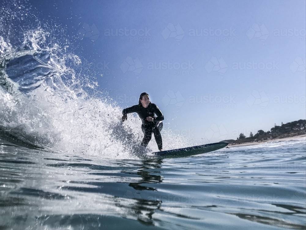 Woman surfing wave on longboard - Australian Stock Image